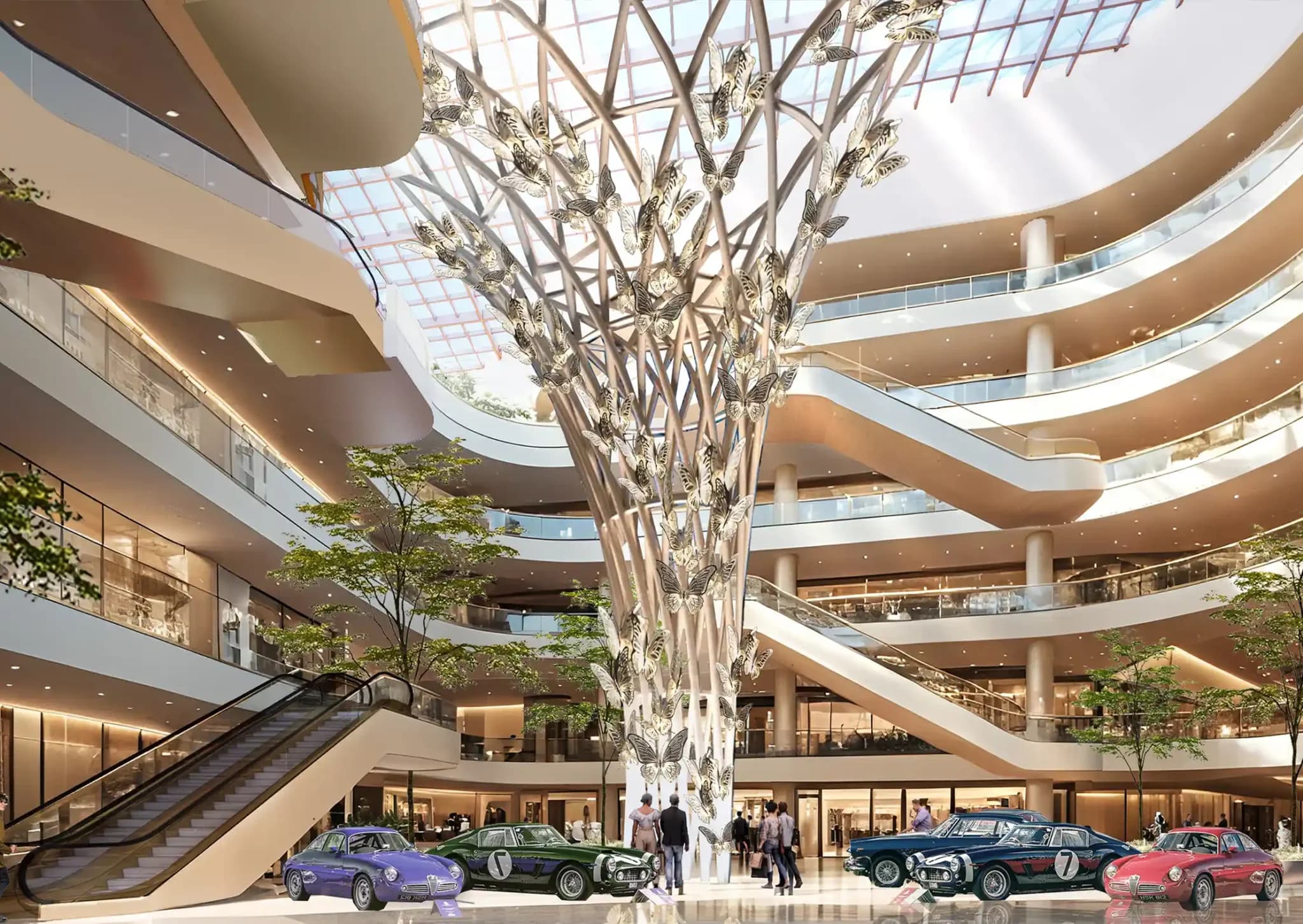 A multi-story modern mall interior with an artistic, large, white tree-like sculpture in the center, with classic cars displayed on the ground floor.